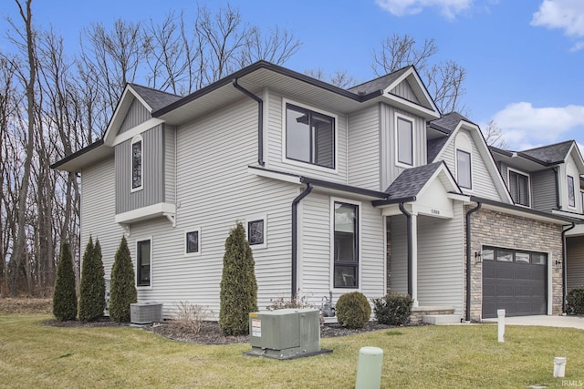 view of front of property featuring a front lawn, a garage, and cooling unit