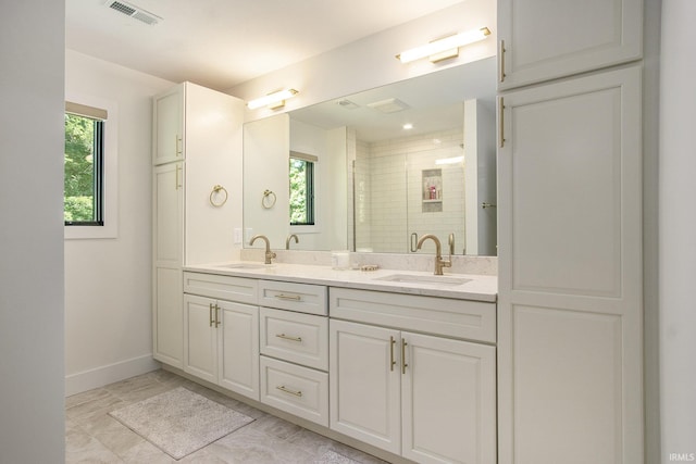 bathroom featuring plenty of natural light, vanity, and walk in shower