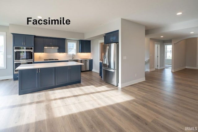 kitchen with plenty of natural light, a center island, stainless steel appliances, and light hardwood / wood-style floors