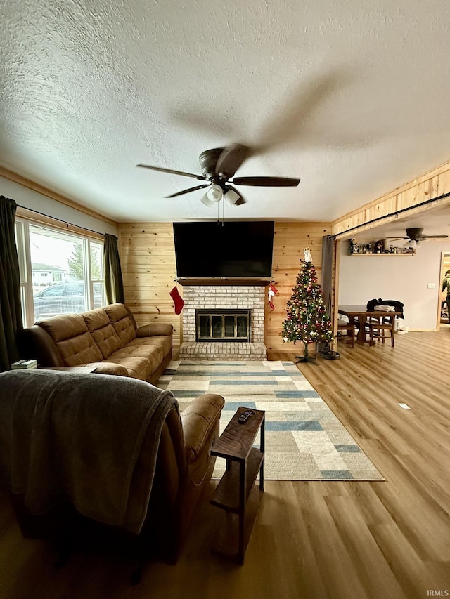 living room featuring hardwood / wood-style flooring, wood walls, and a textured ceiling