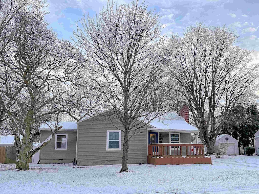 snow covered property with a garage and an outdoor structure