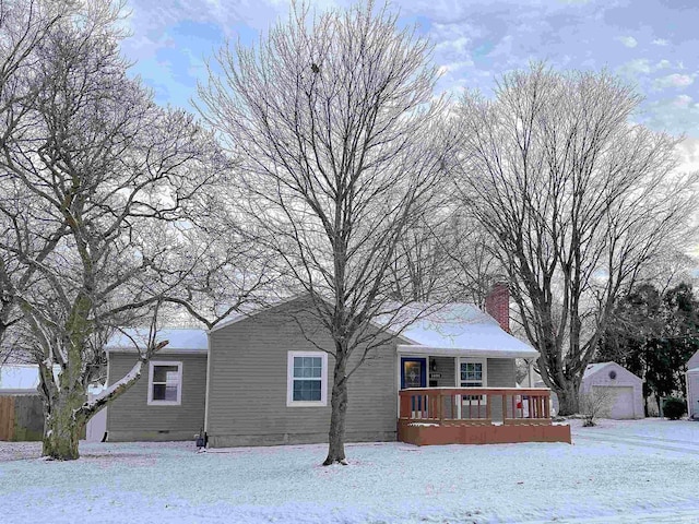 snow covered property with a garage and an outdoor structure