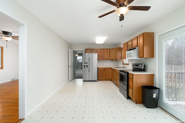 kitchen with ceiling fan, a healthy amount of sunlight, sink, and appliances with stainless steel finishes