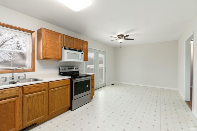 kitchen featuring stainless steel electric stove, ceiling fan, and sink