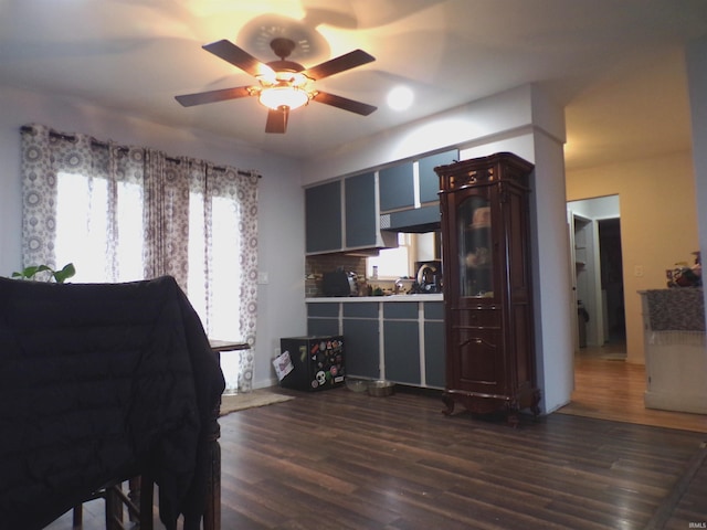 interior space featuring ceiling fan, decorative backsplash, and dark wood-type flooring