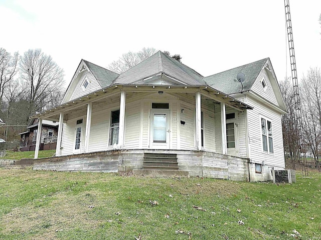 view of front of house featuring a front yard, a porch, and central air condition unit