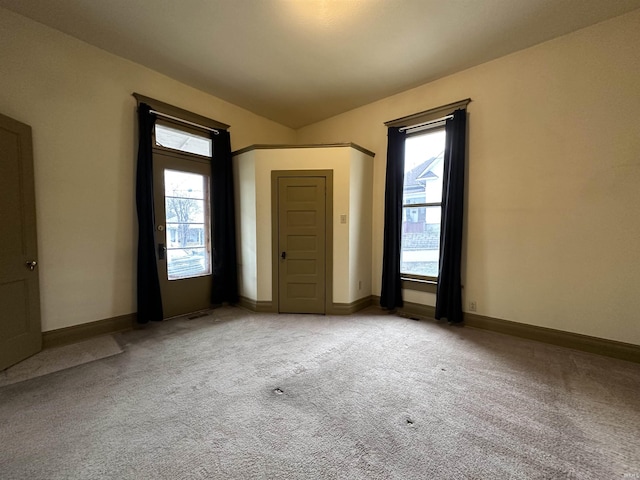 unfurnished room featuring light colored carpet and a healthy amount of sunlight