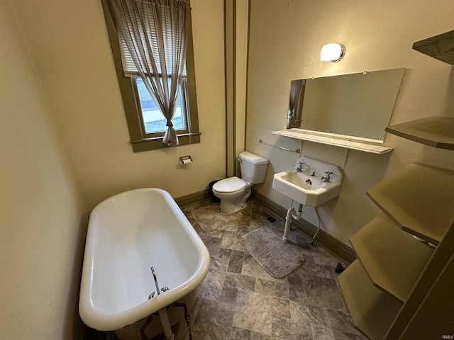 bathroom with a bathtub, toilet, and sink