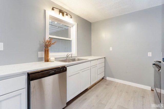 kitchen featuring sink, light hardwood / wood-style flooring, stainless steel dishwasher, a textured ceiling, and white cabinetry