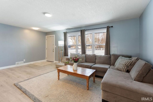 living room with wood-type flooring and a textured ceiling