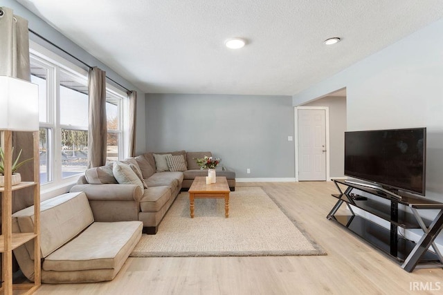 living room featuring a textured ceiling and light hardwood / wood-style flooring