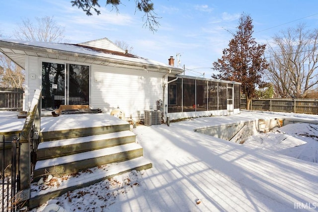 snow covered deck featuring a sunroom