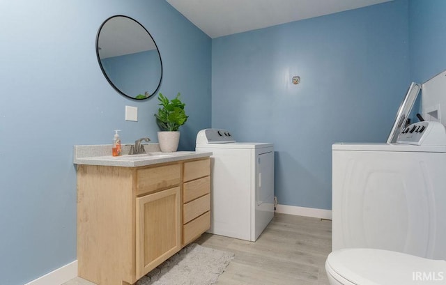 bathroom with washer and clothes dryer, vanity, toilet, and wood-type flooring