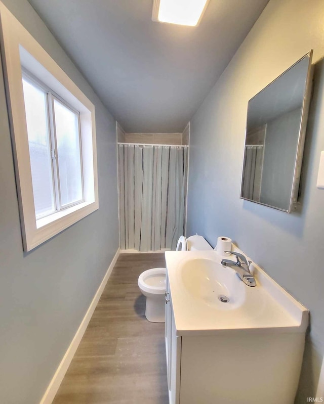 bathroom with hardwood / wood-style floors, vanity, curtained shower, and toilet