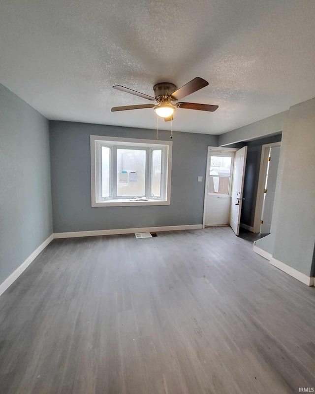 spare room with ceiling fan, wood-type flooring, and a textured ceiling