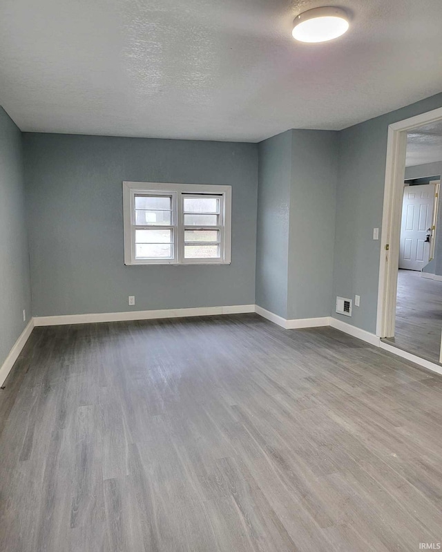 empty room featuring light hardwood / wood-style flooring and a textured ceiling