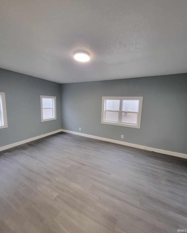 unfurnished room featuring a wealth of natural light and hardwood / wood-style floors