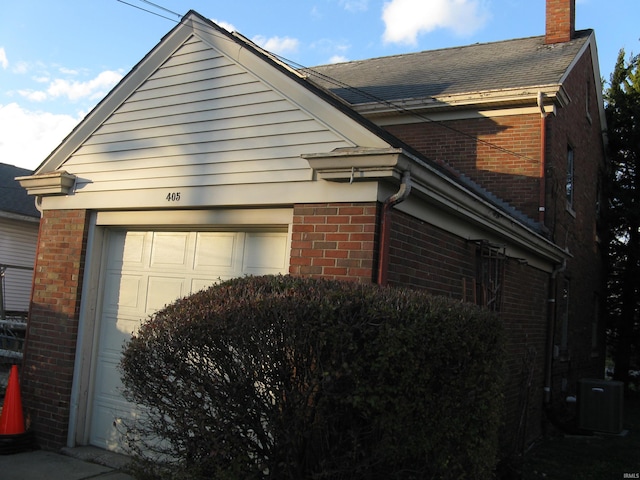 view of home's exterior with central air condition unit and a garage