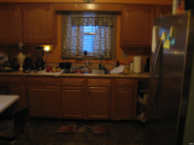 kitchen featuring dark tile patterned flooring, stainless steel refrigerator, and sink