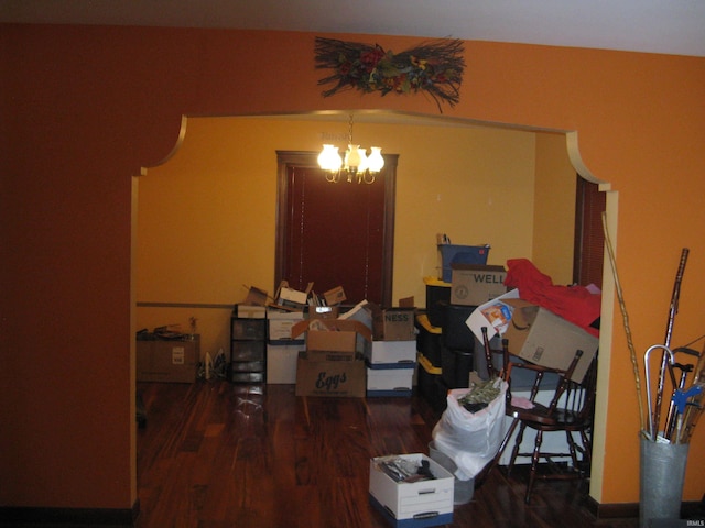 dining area featuring dark wood-type flooring and a notable chandelier