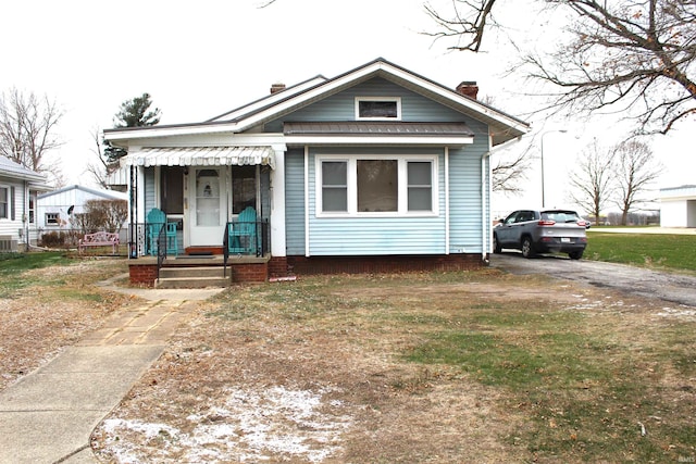 bungalow-style house featuring a front lawn