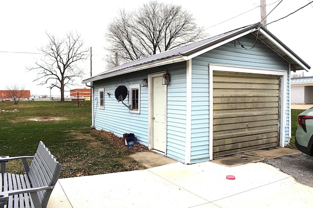 view of outdoor structure featuring a lawn and a garage