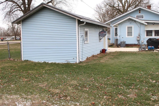 view of side of home with central air condition unit and a lawn