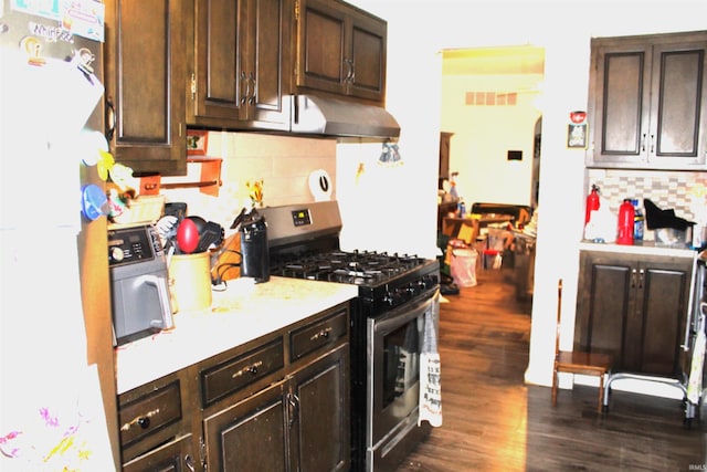 kitchen with backsplash, stainless steel gas range oven, dark brown cabinets, and dark hardwood / wood-style flooring