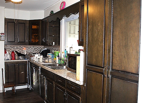 kitchen featuring dark brown cabinets, dark hardwood / wood-style flooring, backsplash, and sink