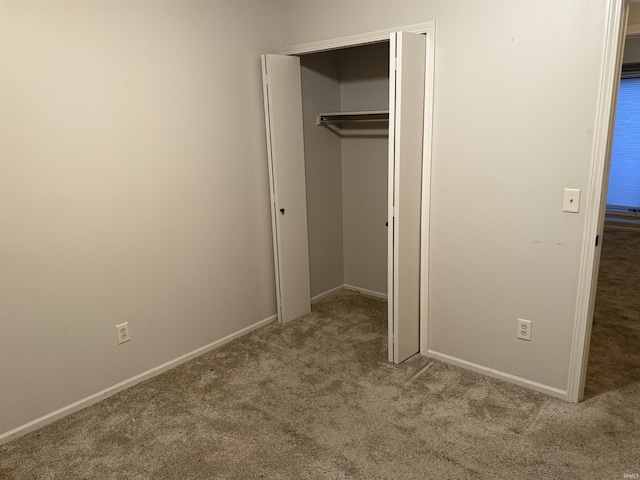 unfurnished bedroom with light colored carpet and a closet