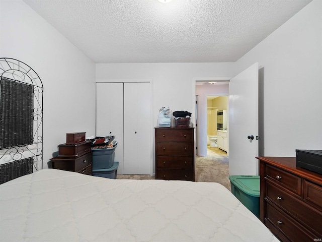 bedroom featuring light colored carpet, a textured ceiling, and a closet