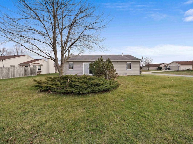 rear view of house featuring a yard