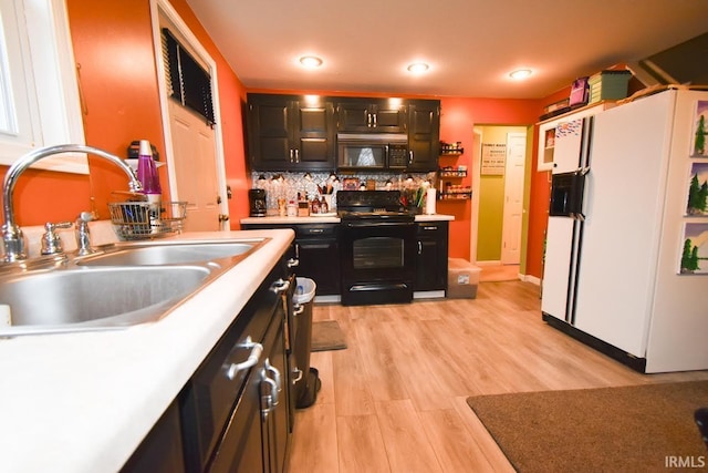 kitchen featuring decorative backsplash, sink, black appliances, and light wood-type flooring