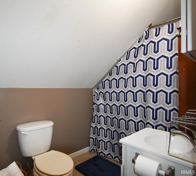 bathroom with vaulted ceiling, toilet, and sink