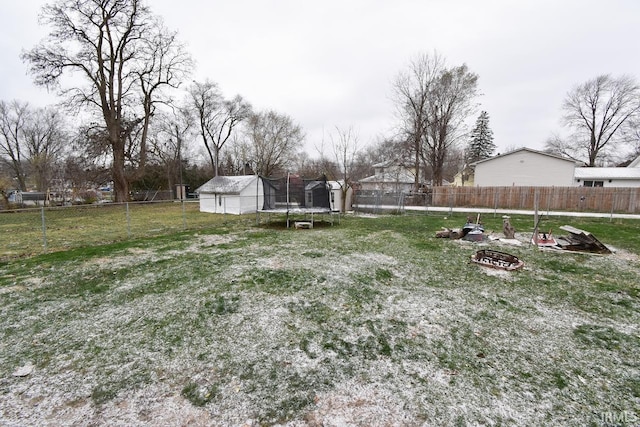 view of yard featuring a trampoline and a fire pit