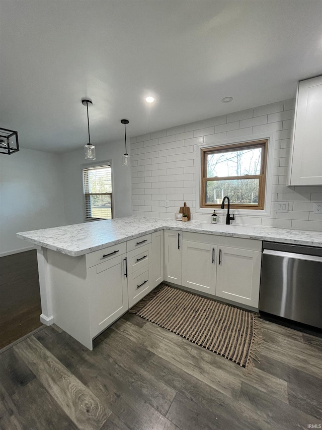 kitchen with white cabinetry, dishwasher, dark hardwood / wood-style flooring, kitchen peninsula, and pendant lighting