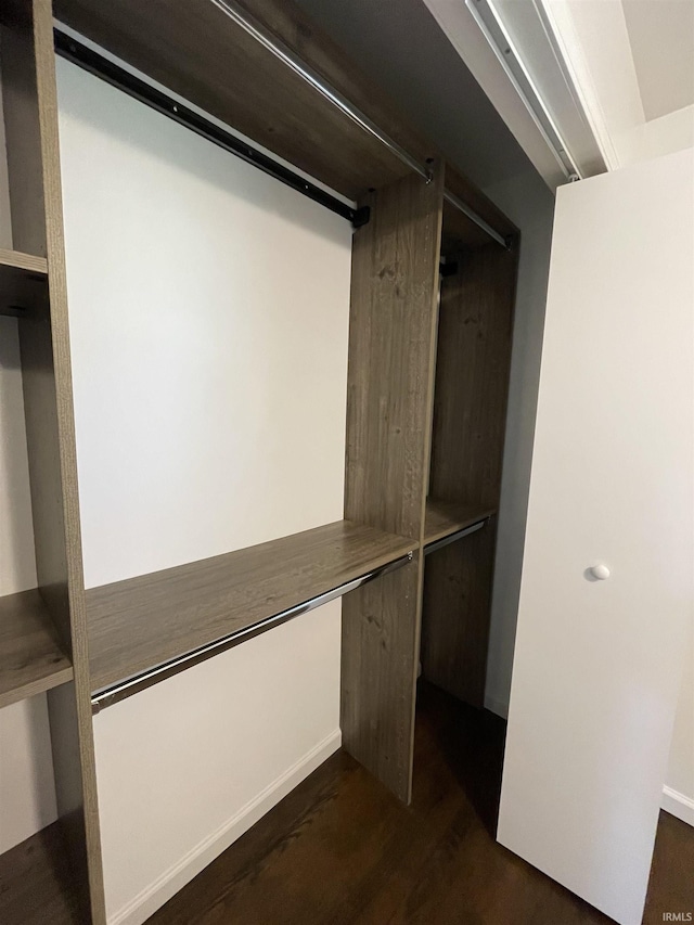 walk in closet featuring built in desk and dark hardwood / wood-style floors