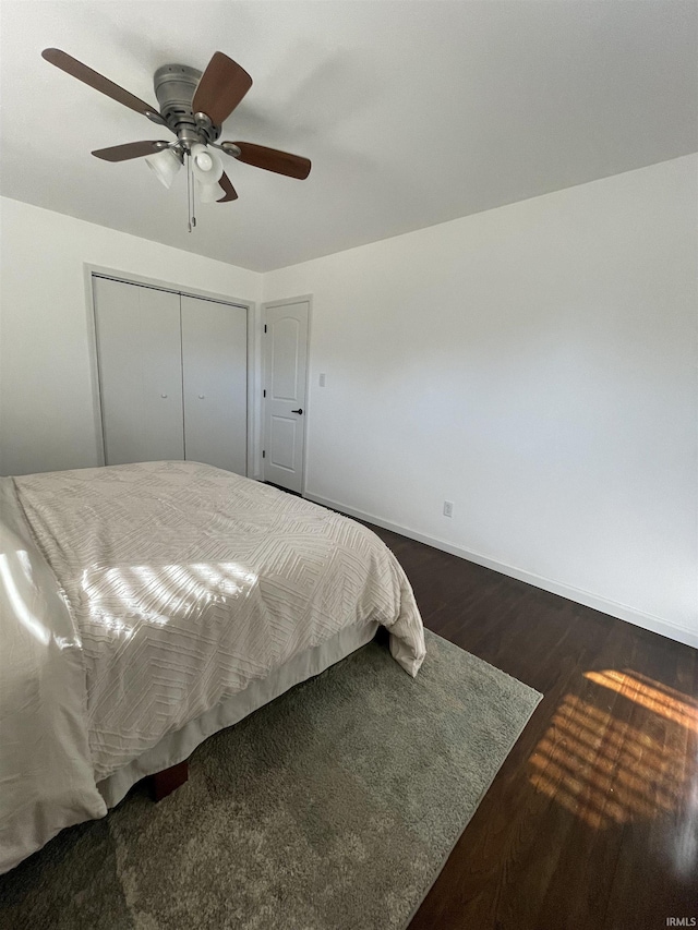 bedroom featuring dark hardwood / wood-style flooring, a closet, and ceiling fan