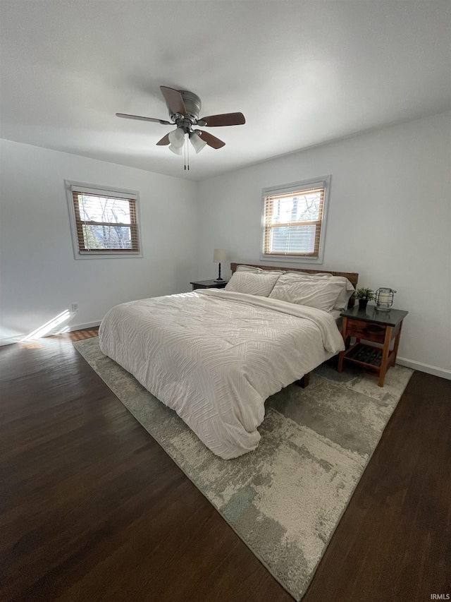 bedroom featuring hardwood / wood-style flooring, ceiling fan, and multiple windows