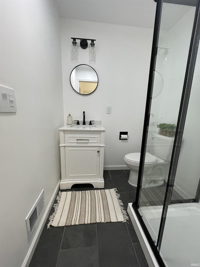 bathroom with tile patterned flooring, vanity, toilet, and a shower with shower door