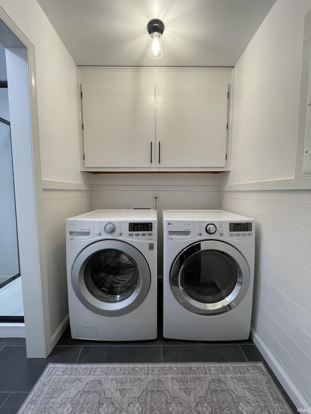 laundry area with cabinets, independent washer and dryer, and dark tile patterned flooring