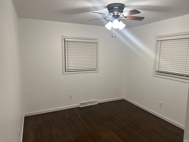 unfurnished room with dark hardwood / wood-style flooring and ceiling fan