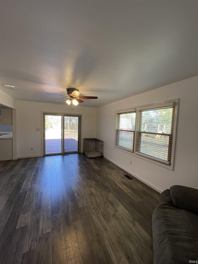 unfurnished living room with dark hardwood / wood-style floors and ceiling fan