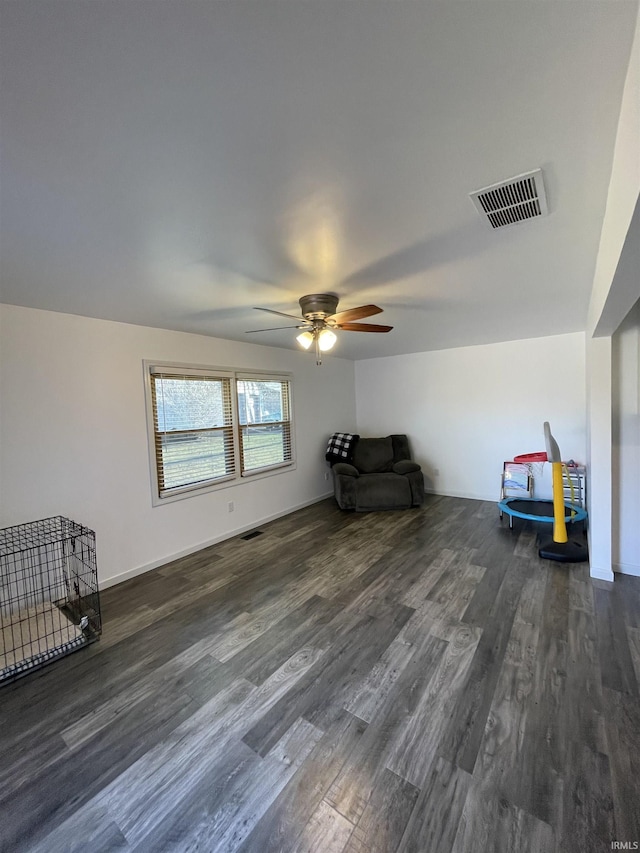 unfurnished room with ceiling fan and dark hardwood / wood-style flooring