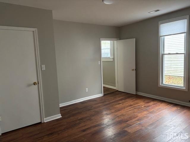 empty room with dark hardwood / wood-style flooring