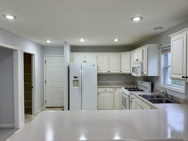 kitchen featuring white cabinetry, sink, and white appliances