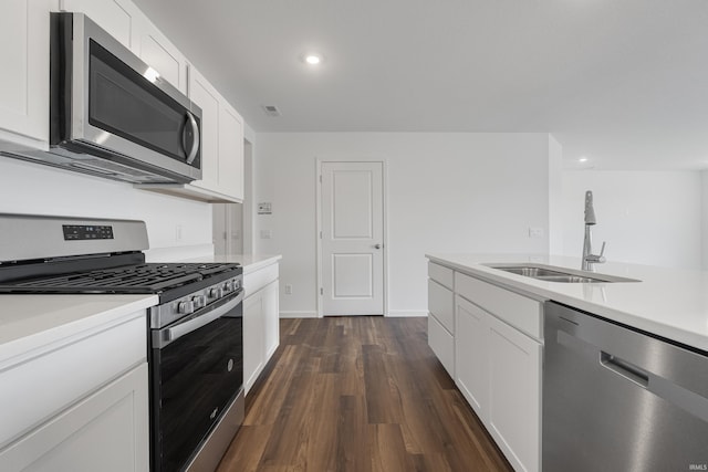 kitchen with dark wood-type flooring, white cabinets, stainless steel appliances, and sink