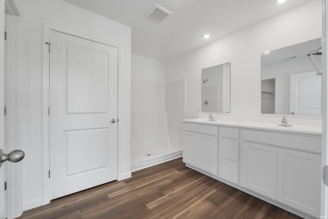 bathroom featuring vanity, a shower, and wood-type flooring