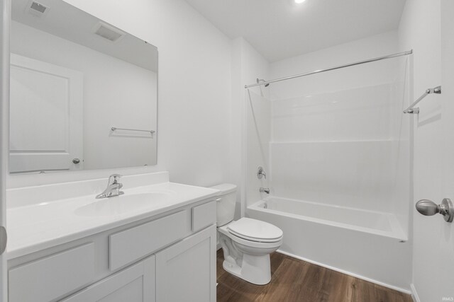 full bathroom with hardwood / wood-style floors, vanity, shower / bath combination, and toilet