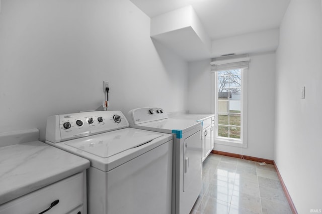 laundry room featuring cabinets, washer and clothes dryer, and light tile patterned flooring